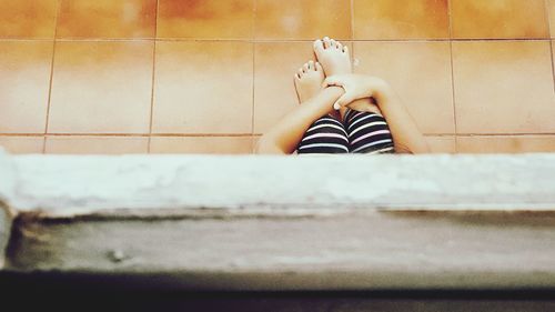 Low section of child sitting on floor