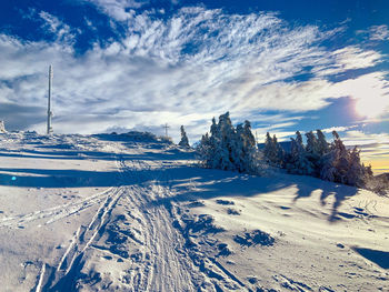 Panoramic view of snow covered land against sky