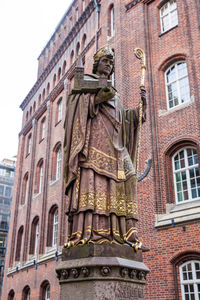 Low angle view of statue against historic building