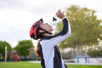 Side view of male athlete drinking water