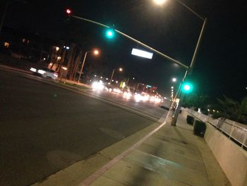 Road passing through illuminated city at night