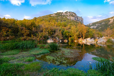 Scenic view of lake by mountain against sky