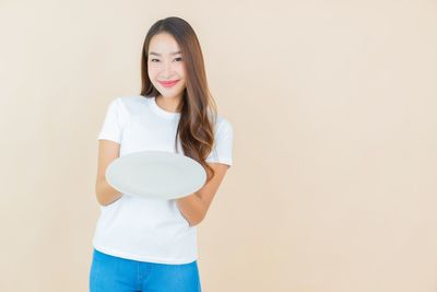 Portrait of smiling woman standing against white background