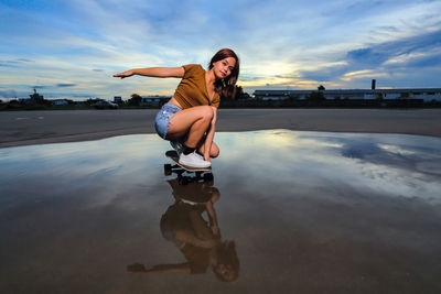 Asian women playing surf skate or skates board outdoors on beautiful summer day. 