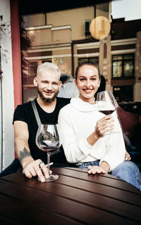 Portrait of a smiling young couple holding drink