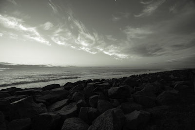 Scenic view of rocks on beach against sky