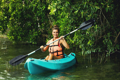 Rear view of man kayaking in lake