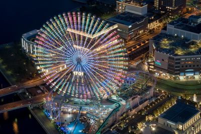 Illuminated ferris wheel in city at night