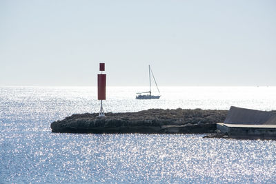 Sailboat on sea against clear sky