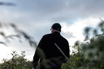 Rear view of man standing against sky