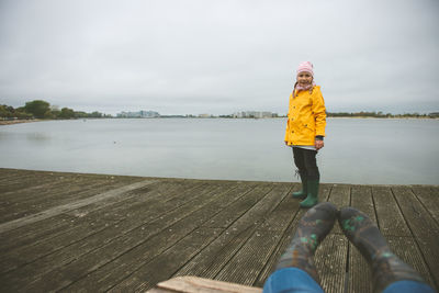 Portrait of girl standing on pier over lake