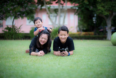 Siblings lying on grassy land in park