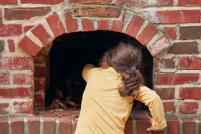 Pretty young girl playing with a brick stove at a farming exhibition