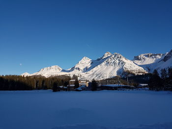 Scenic view of snowcapped mountains against clear blue sky