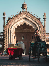 View of people riding in front of historical building