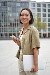 Portrait of young woman using mobile phone