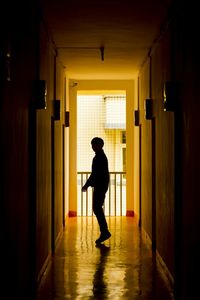 Full length of silhouette person standing in corridor