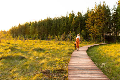 Rear view of man walking on dirt road