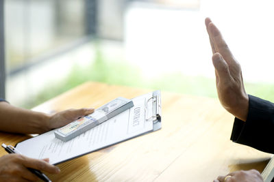 Midsection of man using mobile phone on table