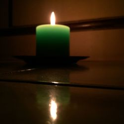 Close-up of lit candle in dark room