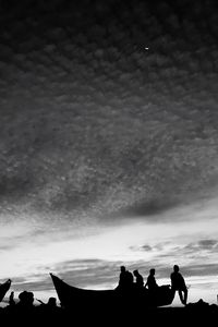 Low angle view of silhouette people against cloudy sky