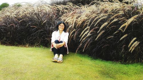 Portrait of young woman standing on field