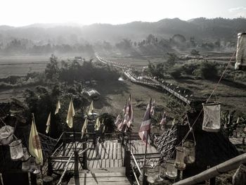 Flags on footbridge against landscape