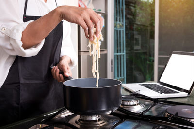 Midsection of male chef preparing food in kitchen