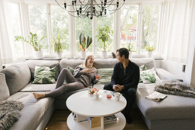 Happy couple having juice while spending leisure time at home