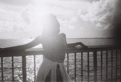 Rear view of woman looking at sea against sky