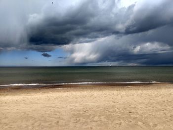 Scenic view of sea against storm clouds