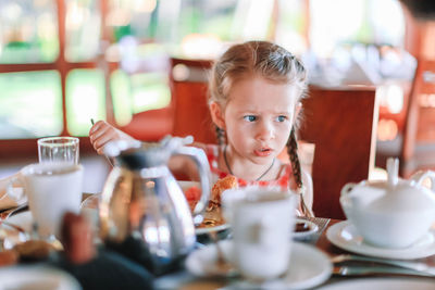 Portrait of boy sitting on table at restaurant