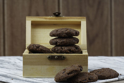 Dark chocolate cookies inside the treasury box over wooden background. national cookie day