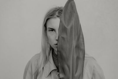 A portrait of a young woman holding a plant leaf