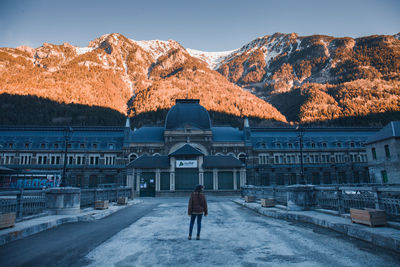 Rear view of person on snowcapped mountain against sky