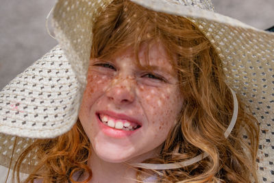 Close-up portrait of smiling girl wearing sun hat