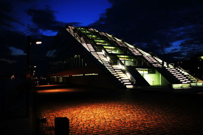 Low angle view of illuminated building against sky at night