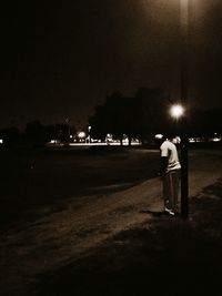Full length of illuminated woman standing at night