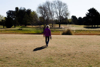 Rear view of woman running on field