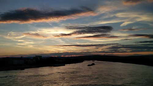 Scenic view of sea against cloudy sky at sunset