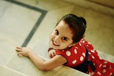 High angle portrait of girl sitting on steps at home