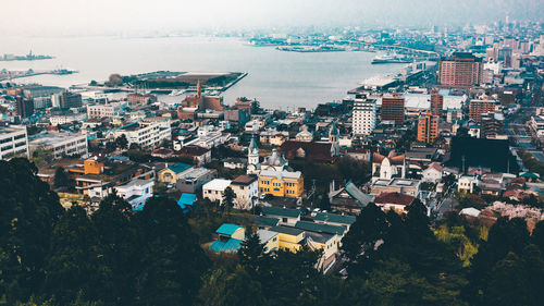 High angle view of townscape by sea against sky