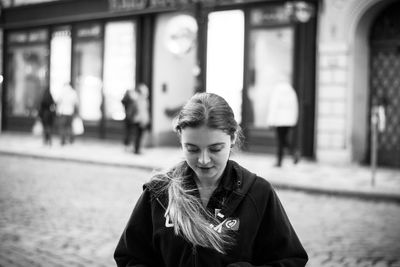 Woman looking down in city