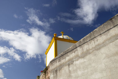 Low angle view of flags on building against sky