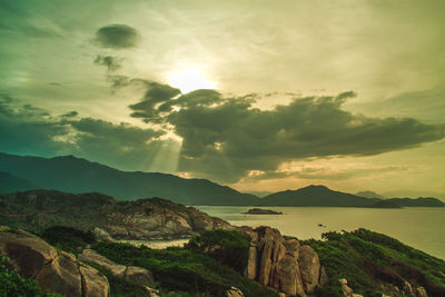 Scenic view of sea and mountains against sky during sunset