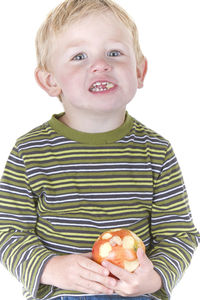 Portrait of boy eating apple over white background