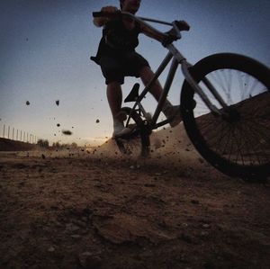 Silhouette bicycle on field against sky