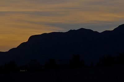 Scenic view of silhouette mountains against sky at sunset