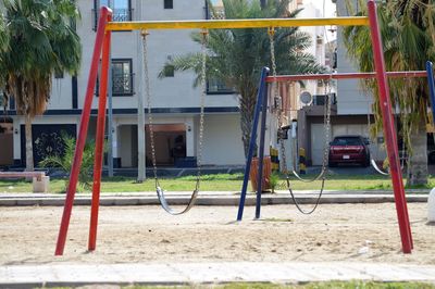 View of playground against trees and building