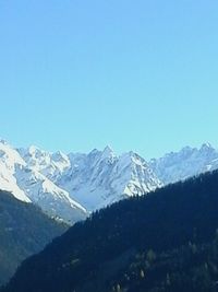 Scenic view of snow covered mountains against clear sky